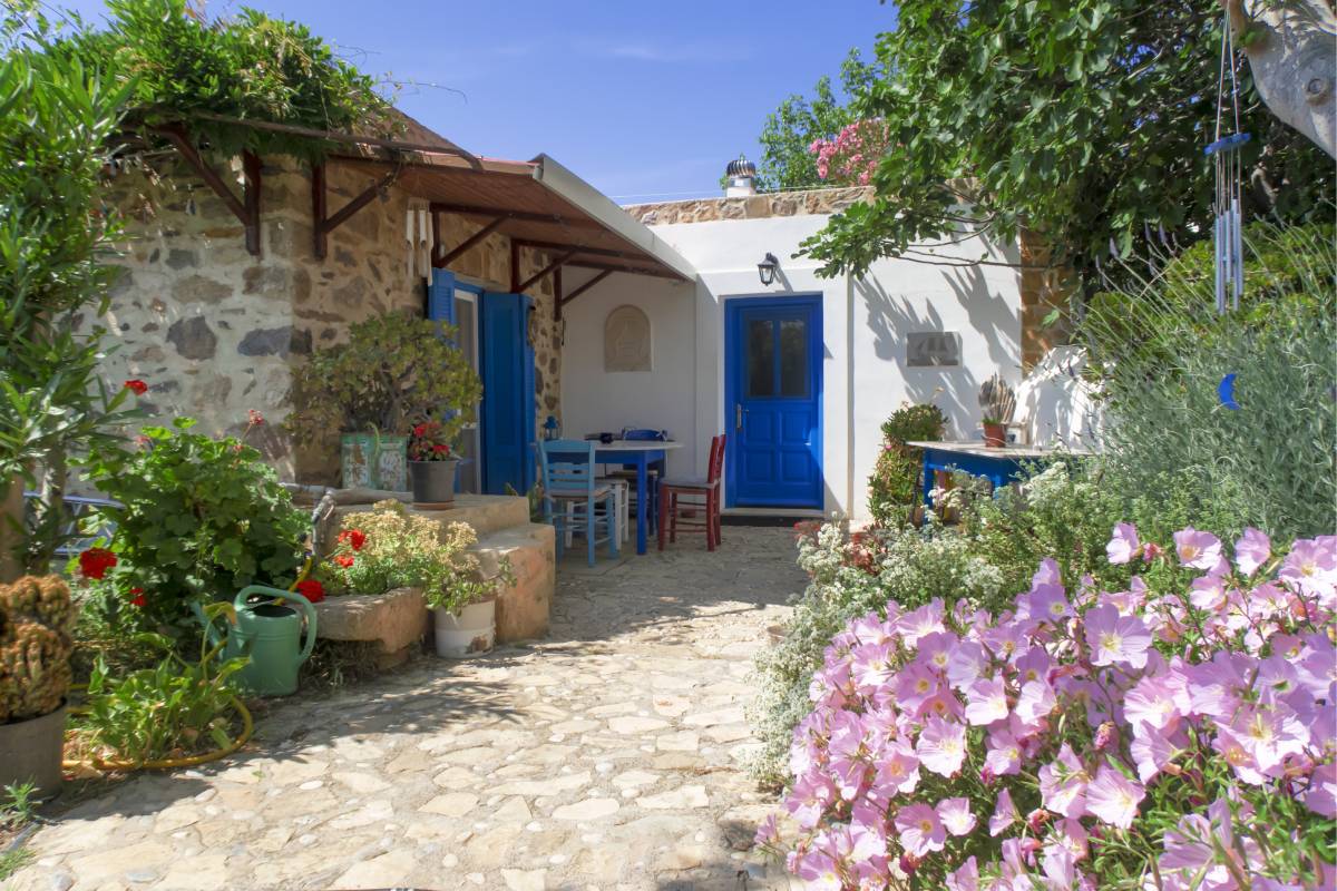 Exterior view of the traditional-style house surrounded by vibrant flowers.