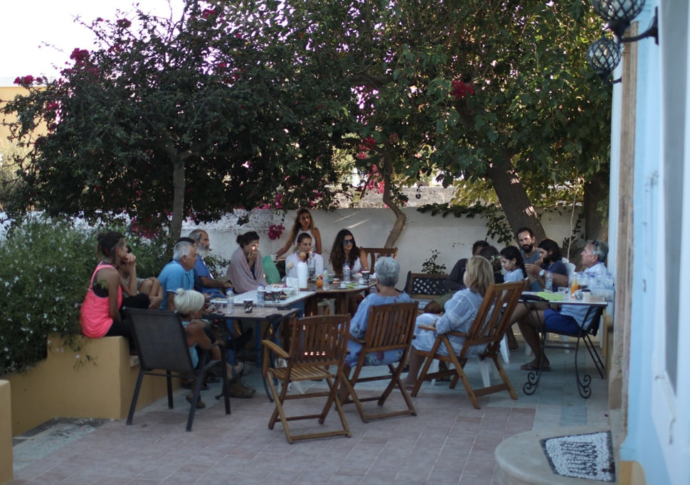 Participants discussing on a patio under the trees